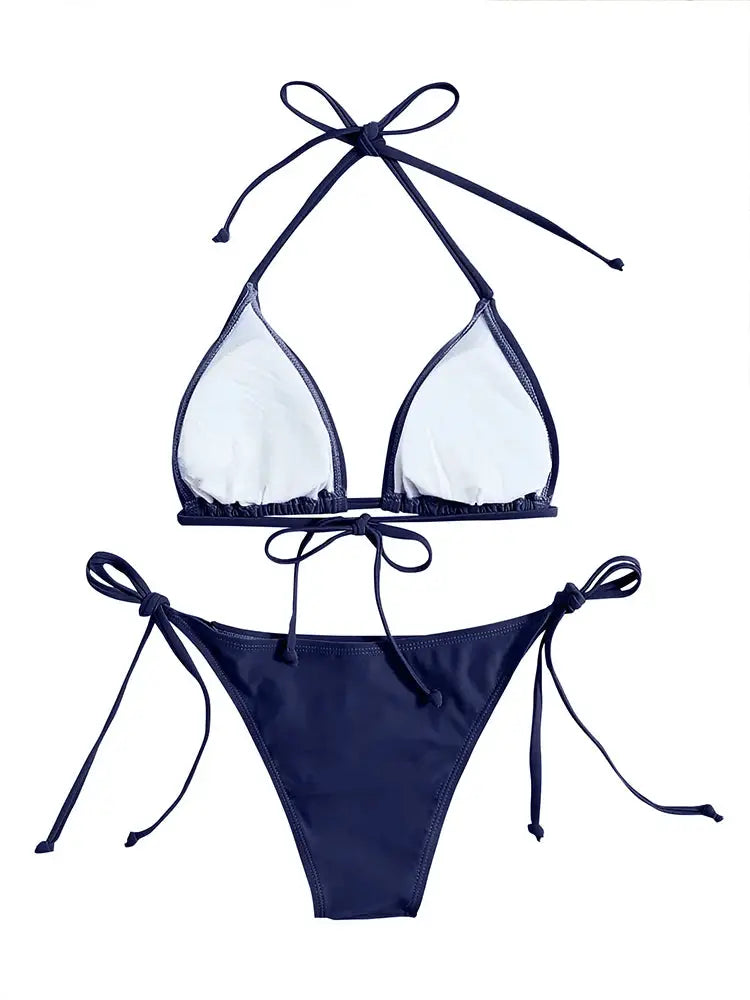 Navy blue two-piece thong bikini set with white triangle halter top and navy tie-side bottoms.
