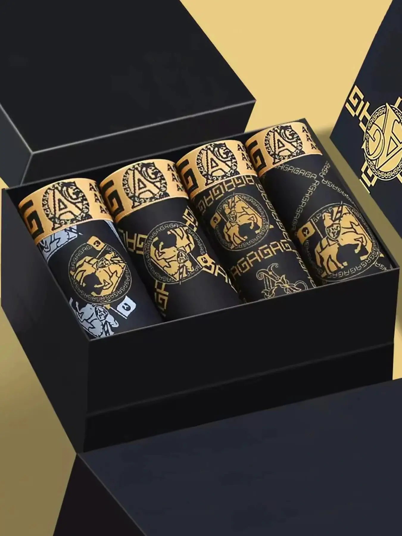 4-pack men's boxer shorts in black and gold retro print, shown in a black gift box.