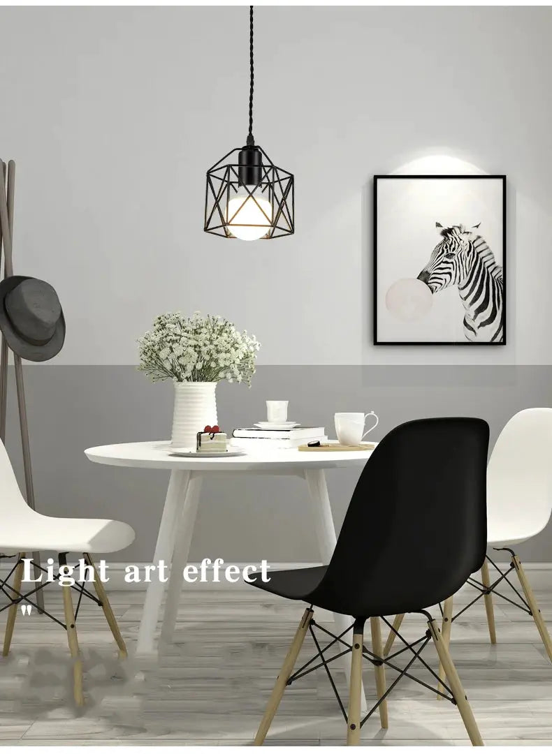 Modern LED pendant light with black metal cage and globe bulb over a dining table