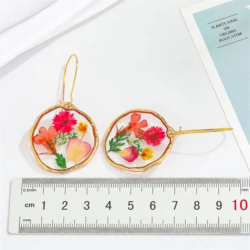 Natural flower epoxy resin dangle earrings by Simples Market, gold-tone bezel with colorful pressed blossoms (pair)