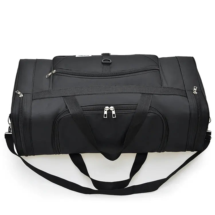 Oversized black handbag with multiple zip compartments, two top handles, and a long shoulder strap