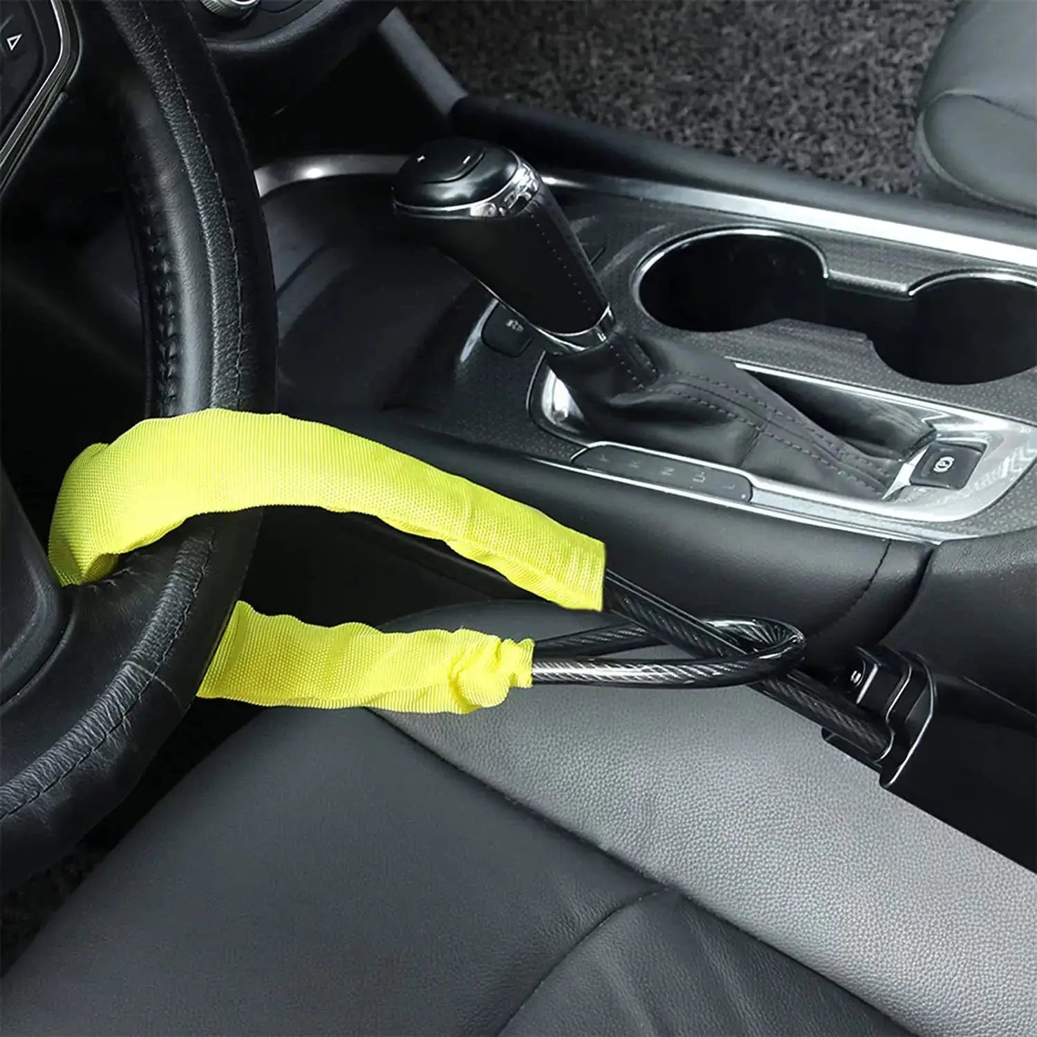 Steering wheel anti-theft lock, black steel with neon yellow strap, in a car cabin near the gear selector