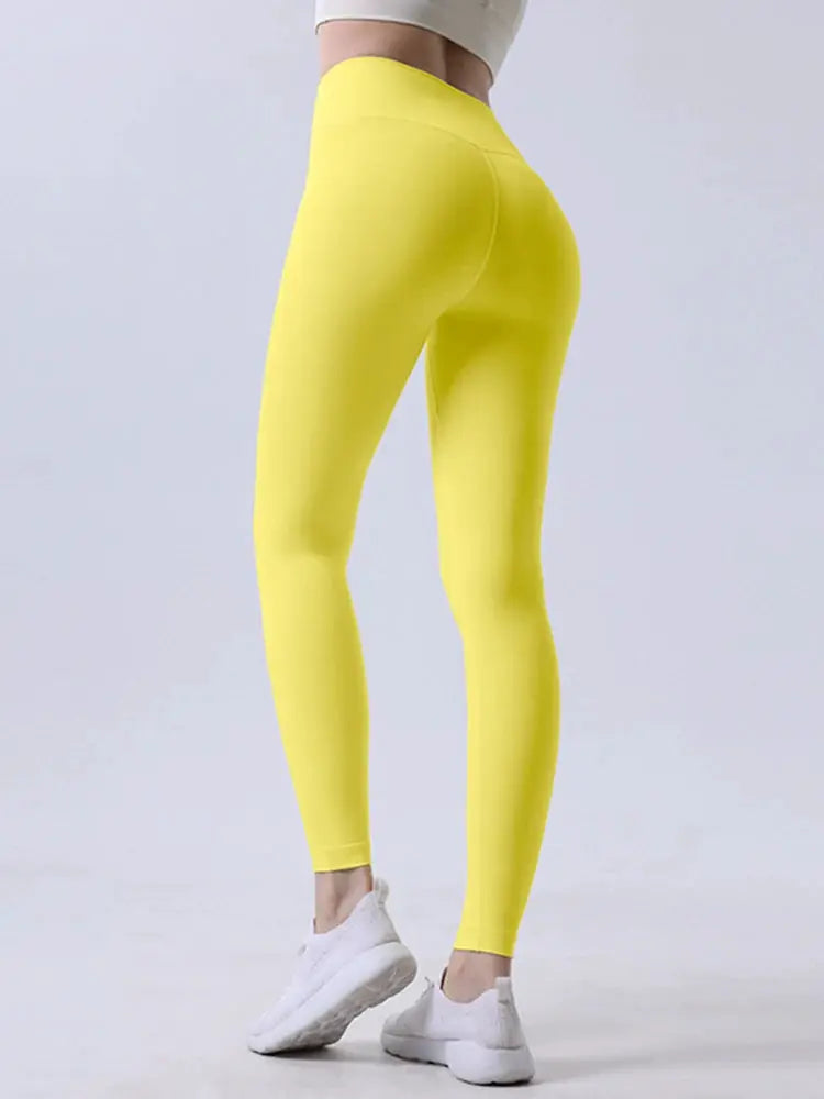 Women’s high-waisted yoga leggings in bright yellow; breathable fitness pants for running and cycling