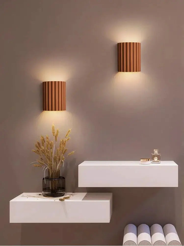 Nordic modern resin wall lamps; two brown ribbed sconces casting warm light over white floating shelves.