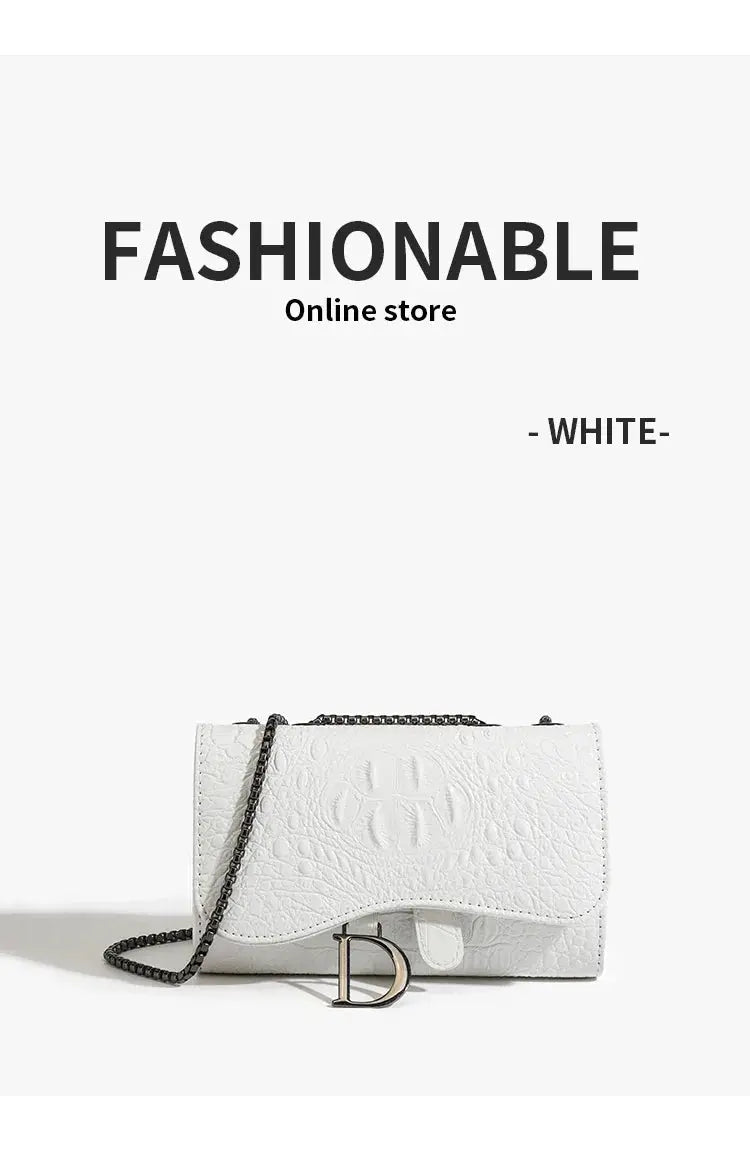 Crossbody bag, white crocodile-textured leather with black chain strap and front D-shaped charm.