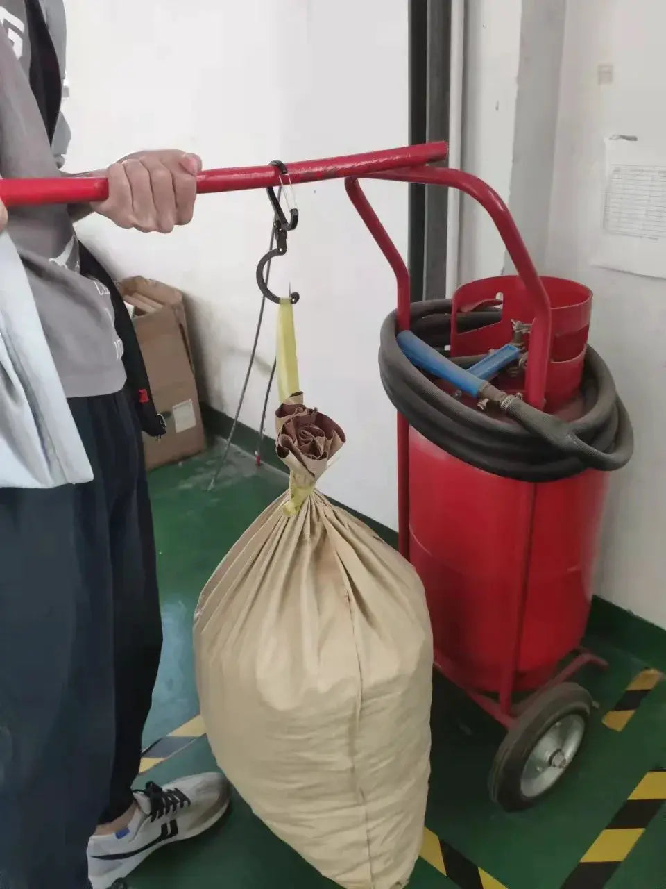 Hybrid gear clip rotating carabiner hook, black non-locking clip attached to a red pole holding beige bag by Simples Market
