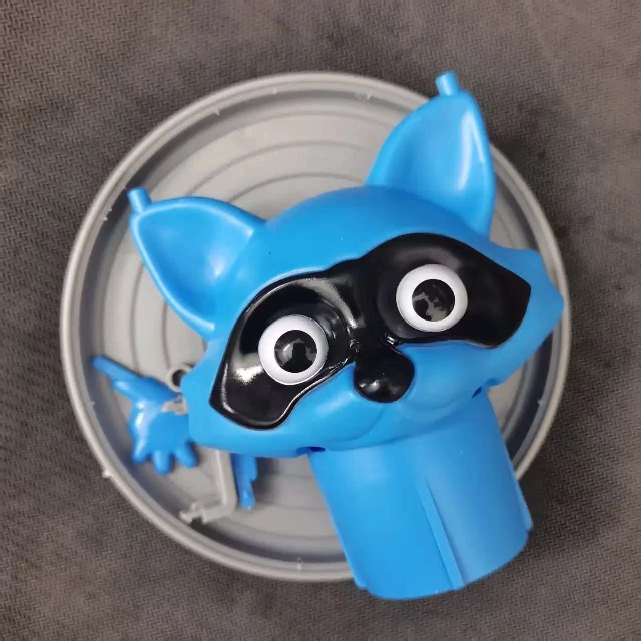 Toilet paper holder featuring a blue cartoon raccoon head by Simples Market