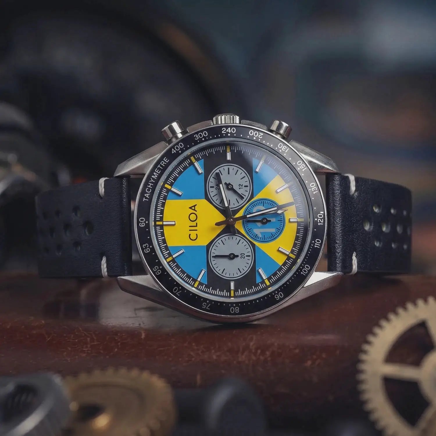 CILOA men's racing chronograph watch with blue-yellow dial, black tachymeter bezel, perforated leather strap.