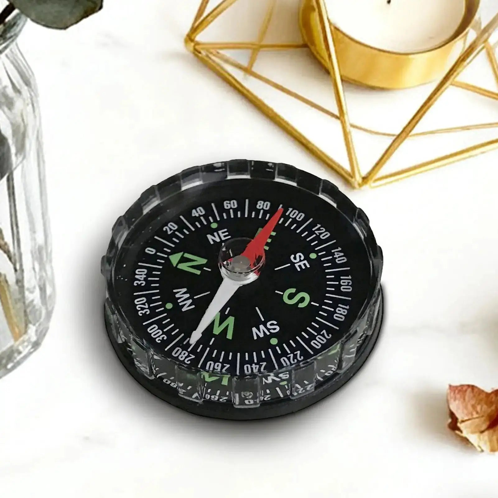 Hiking compass, black waterproof with white markings and red needle.
