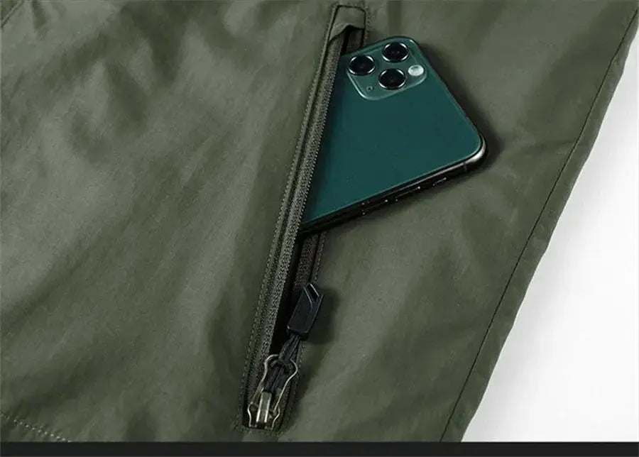 Sleeveless cargo vest olive-green with zip pocket holding a smartphone