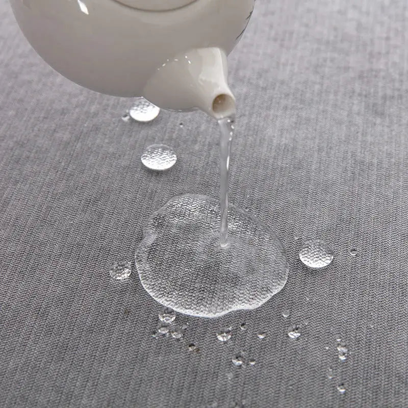 Waterproof gray sofa towel showing spill resistance on fabric surface