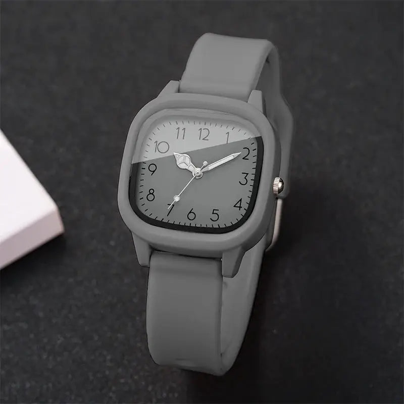 Grey silicone-band quartz wristwatch with Arabic numerals on a rounded-square dial.
