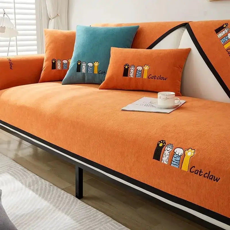 Chenille sofa cushion set on orange cover; includes two orange cushions and one teal cushion with Catclaw embroidery.