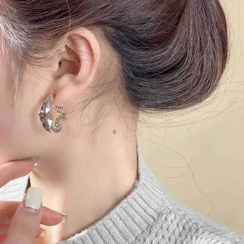 Women's irregular silver metal earrings with abstract curved design