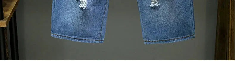 Men's light blue denim shorts with distressed patches, slim fit