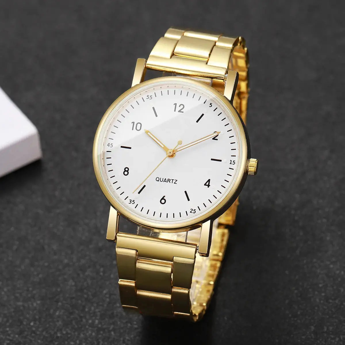 Gold-tone women's quartz wristwatch with bracelet-style link band, white dial, black Arabic numerals; Simples Market.