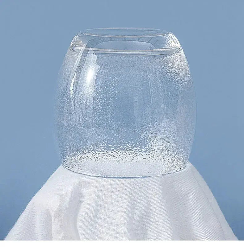 Clear glass jar with rounded body and condensation droplets on blue background