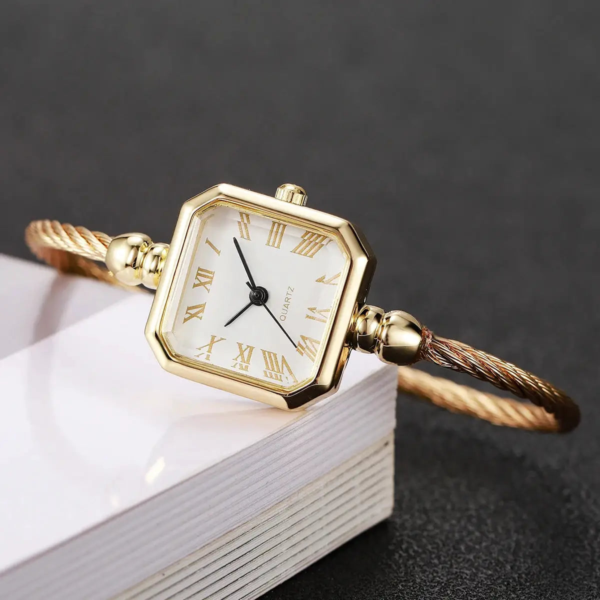 Women's gold-tone square Roma dial quartz watch with bracelet strap and Roman numerals.
