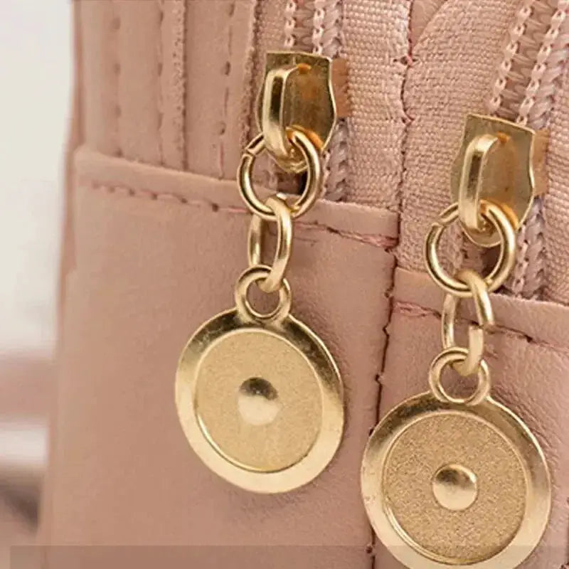Fashion women's mini backpack with pink exterior and gold-tone hardware, featuring dangling circular coin charms.
