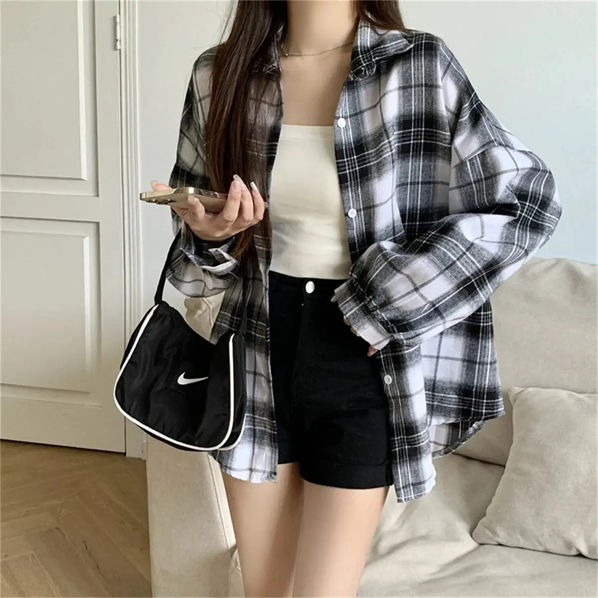 Korean plaid blouse for women in black-and-white, oversized check shirt with white top and black shorts; Nike bag.