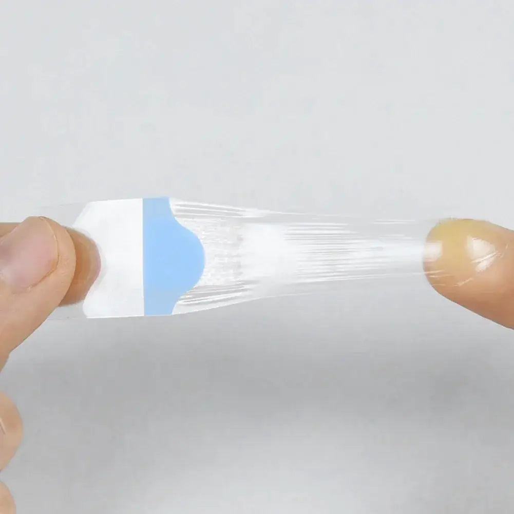 Waterproof transparent adhesive wound plaster with blue backing being peeled from its sheet.