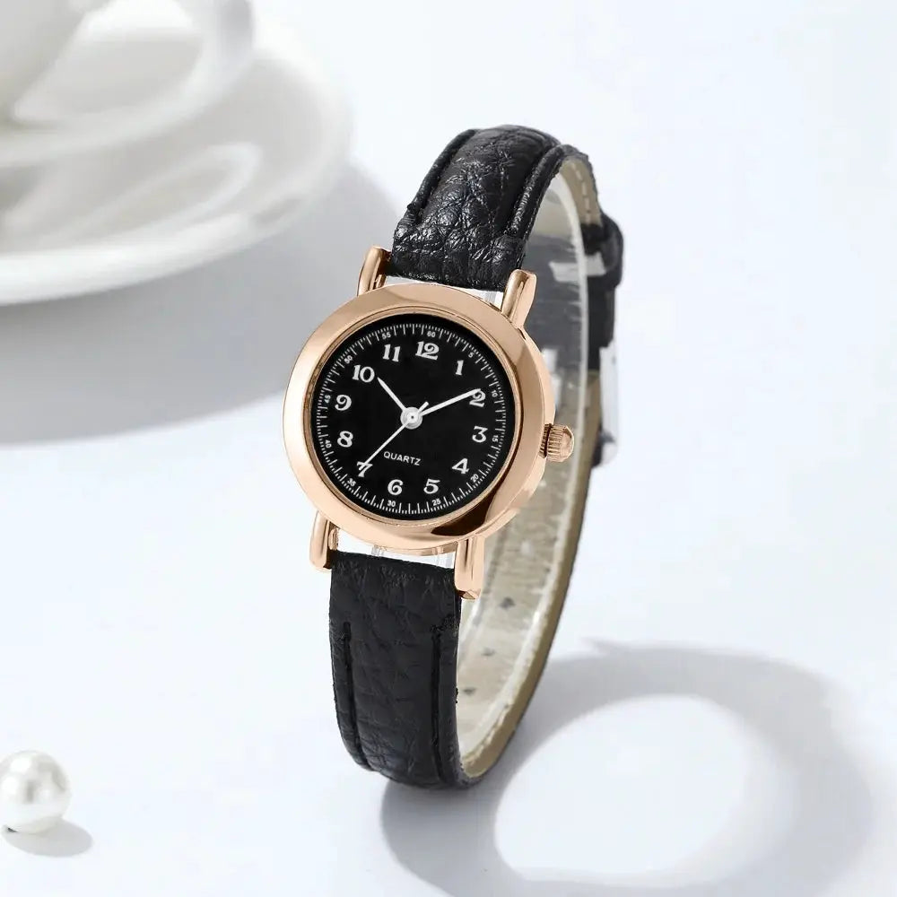 Women's watch with black dial, rose-gold case, black leather strap, quartz movement.