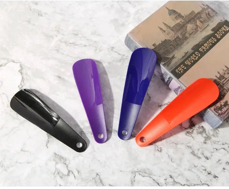 Shoe horn set of four 16 cm plastic short-handle horns in black, purple, blue, and orange.