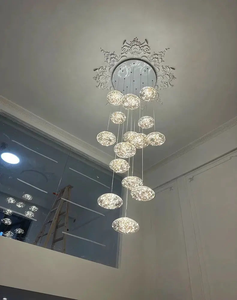 Modern dining room pendant lights with multiple crystal glass spheres hanging from an ornate ceiling medallion.