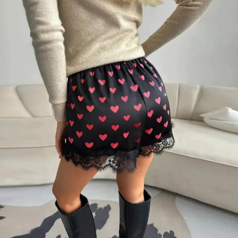 Women's heart-print satin shorts with pink hearts, black base, lace trim, elastic waist
