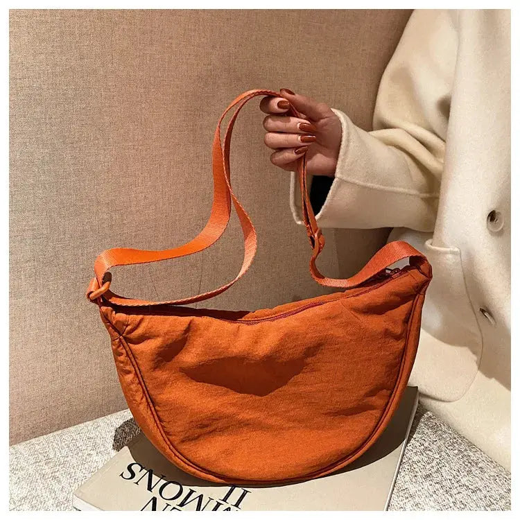 Crossbody bag from Simples Market in orange nylon with padded fabric and shoulder strap