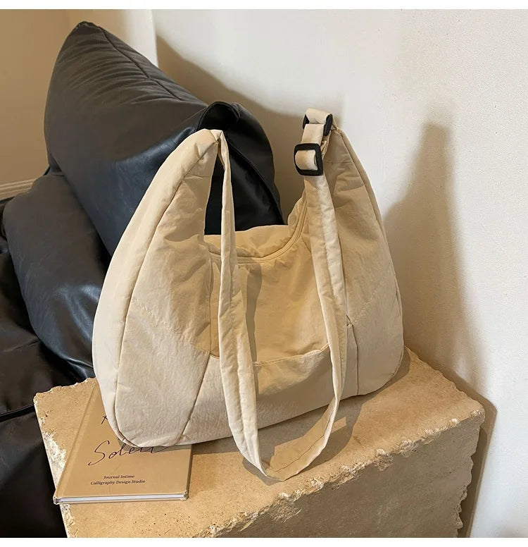 Trendy women's soft-cloth beige shoulder bag with dual top handles and adjustable strap