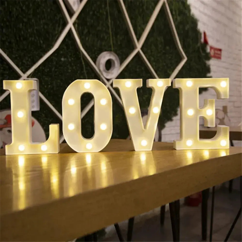 White LED LOVE letter lamp on a wooden table with warm glow for marquee decor