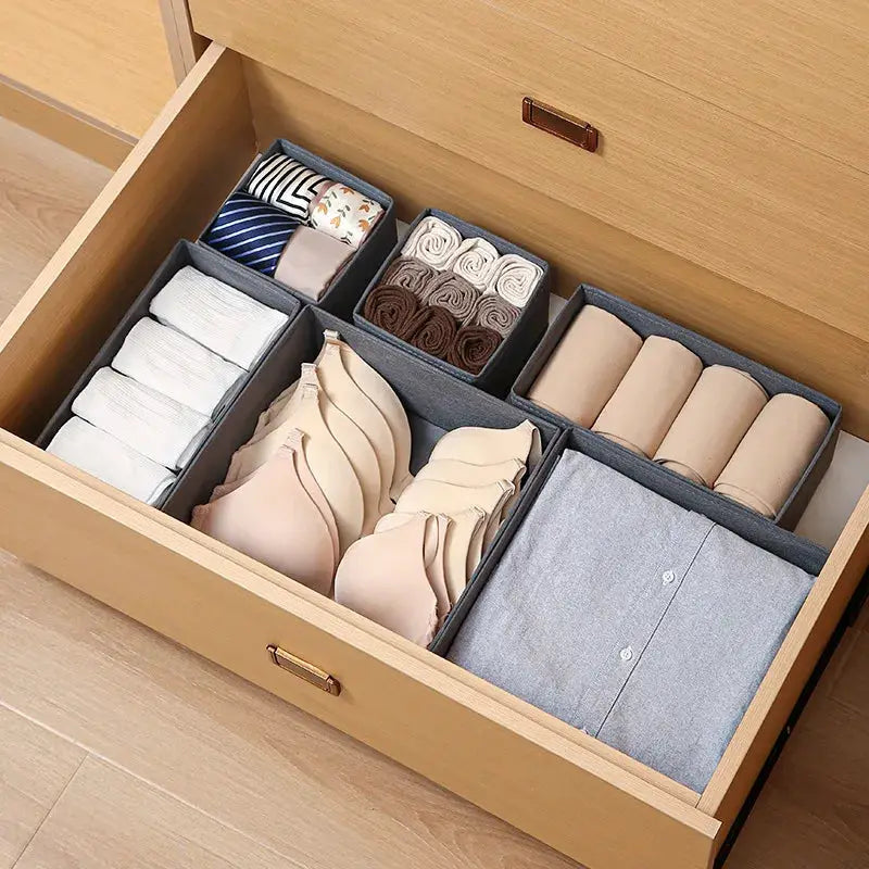 Simples Market fabric gray drawer organizer with compartments for bras, underwear, socks and shirts in a dresser drawer.