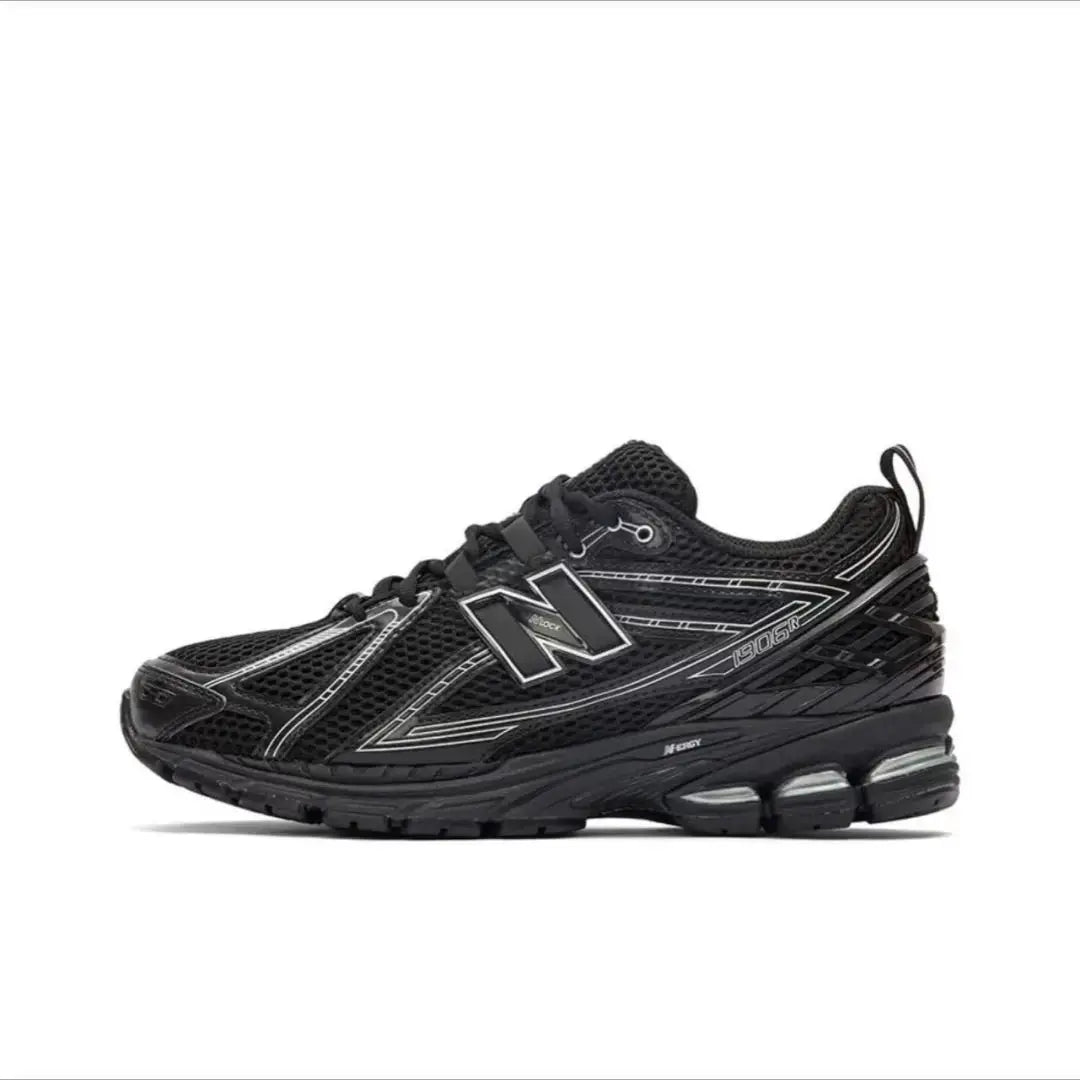 1906R running shoes by Simples Market, black breathable mesh with reflective details and chunky midsole.