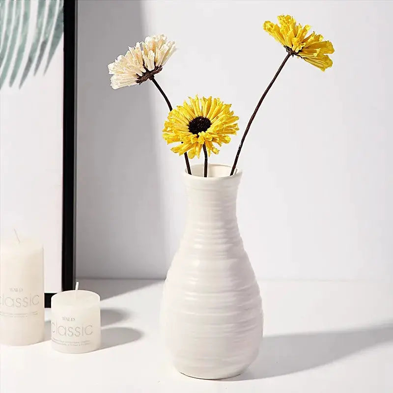 Nordic plastic vase by Simples Market; white ribbed bottle with three flower stems on a white surface.