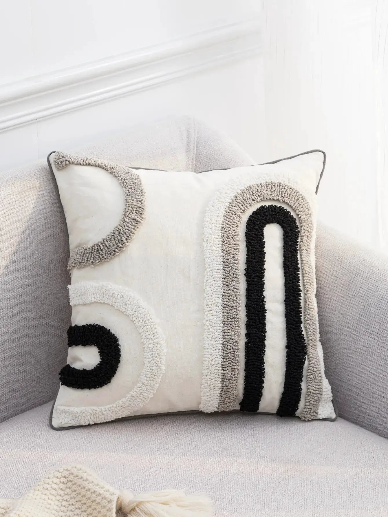 Decorative pillow cover, bohemian style, with black gray white u-shaped pattern and beige trim.