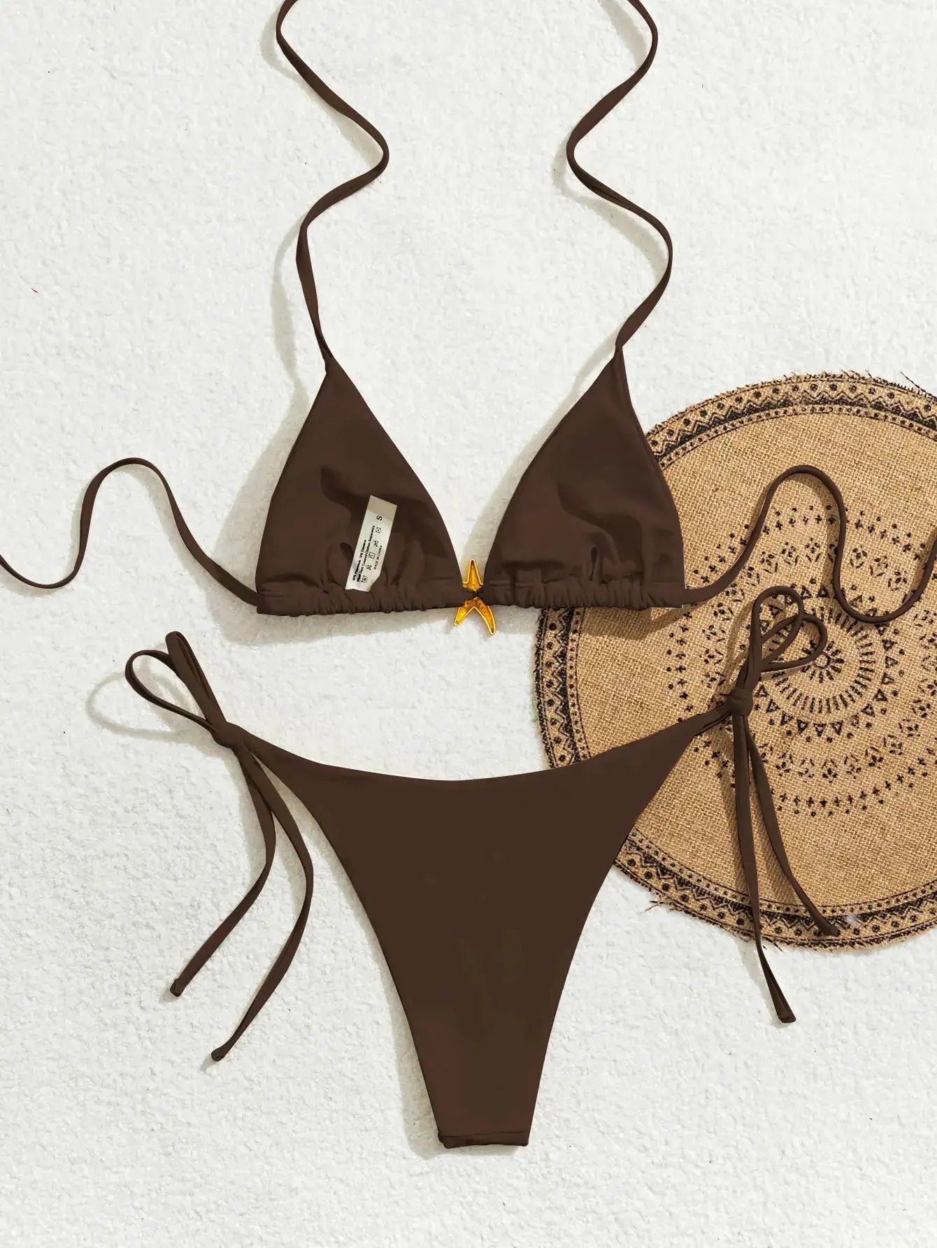 Brown triangle bikini top with string ties and a small gold bow at center; matching Brazilian bottoms.