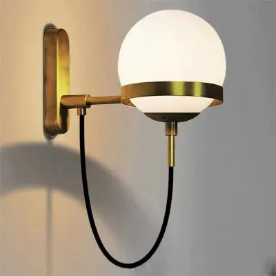 Modern glass ball wall lamp with brass fixture and black cord for living rooms and bedrooms