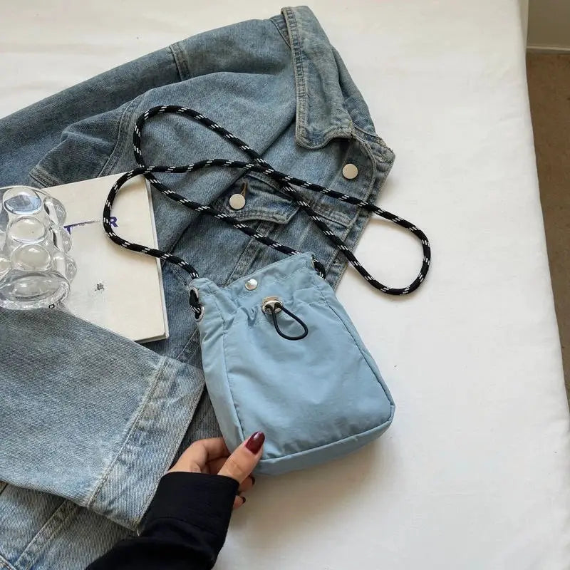 Simples Market nylon crossbody bag, light blue mini square purse with black-and-white striped strap.
