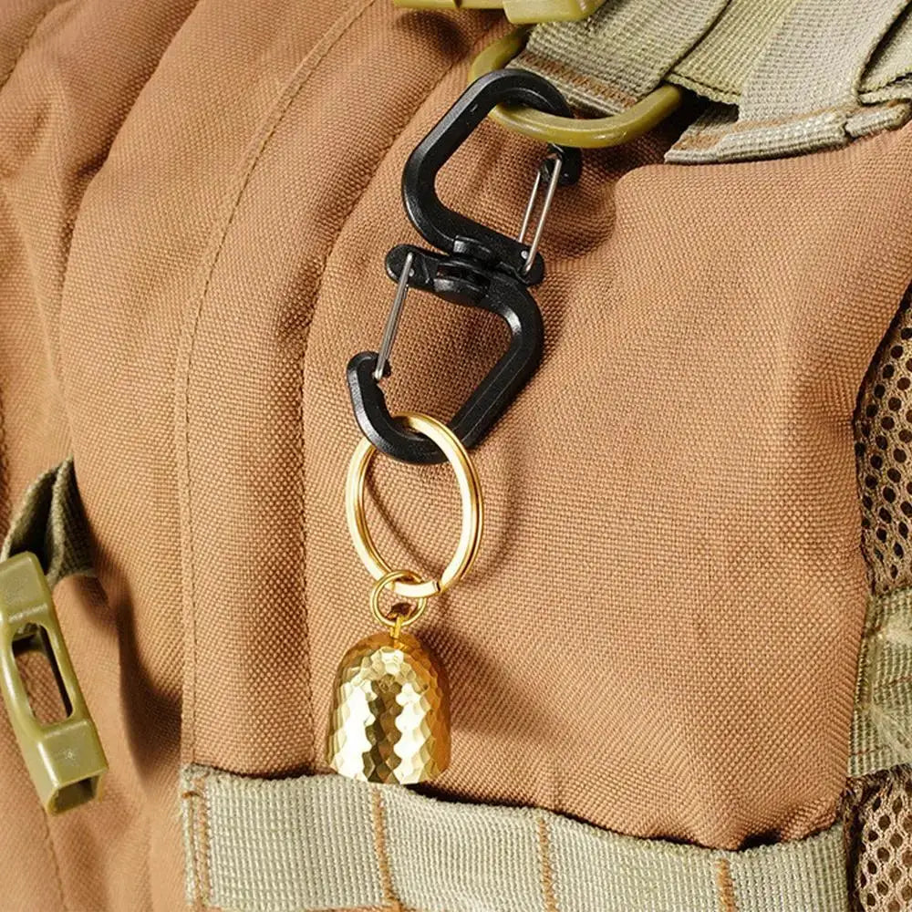 Double clip carabiner with 360 swivel on brown backpack; black clips, gold ring and textured gold charm