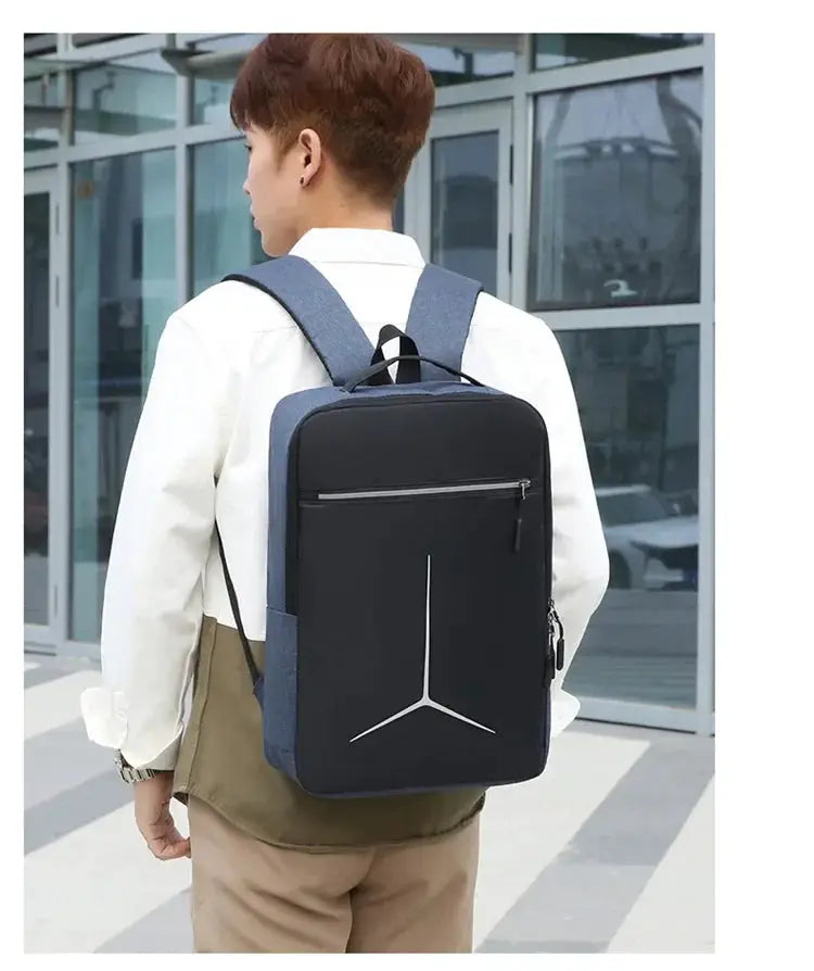 Backpack blue and black with front zip pocket worn by man in white shirt