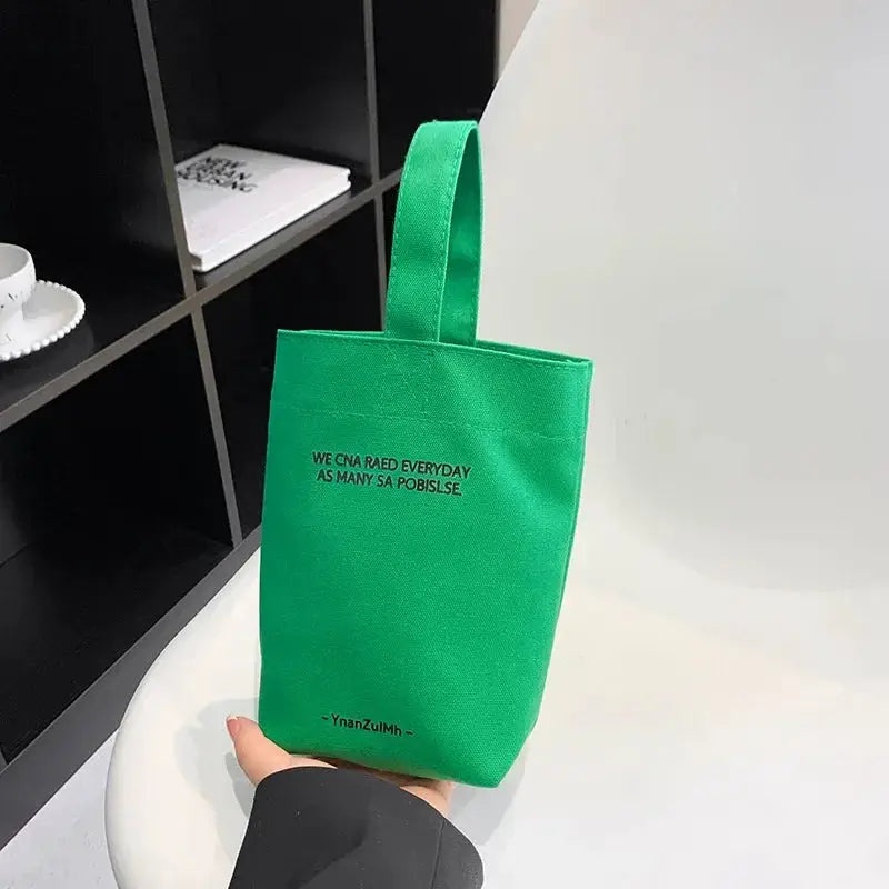 Green canvas tote bag with short handles, a casual large-capacity shopper purse.