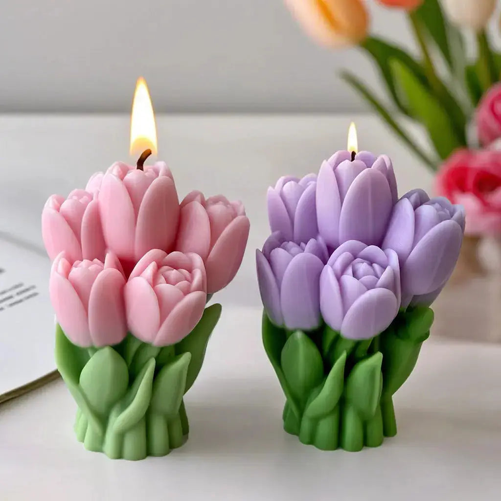 Tulip-shaped candles in pink and purple with green stems, two lit blooms