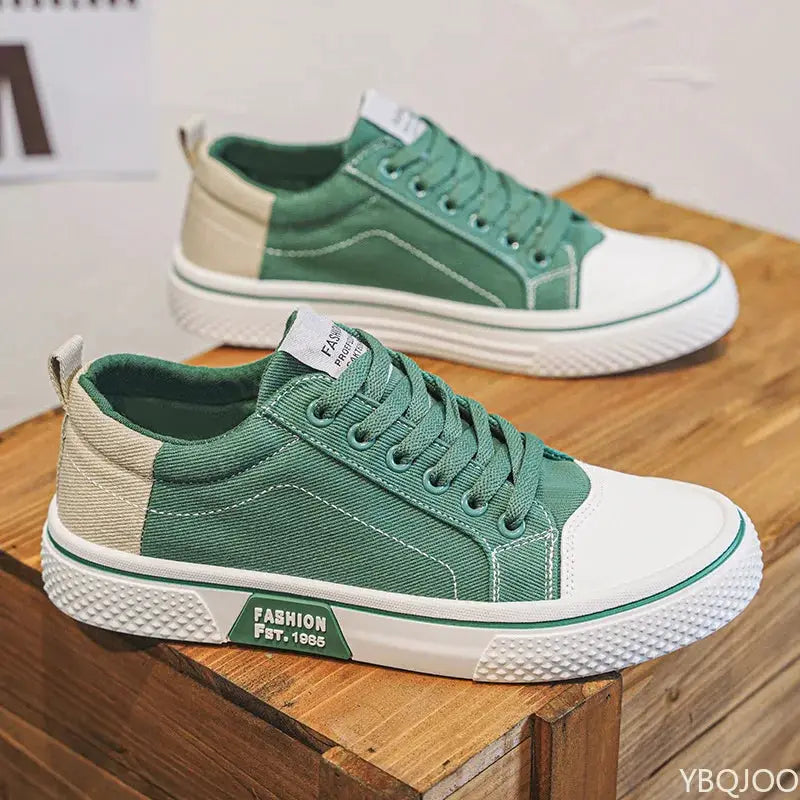 Men's green canvas sneakers with white toe cap and beige heel panel, lightweight casual footwear.