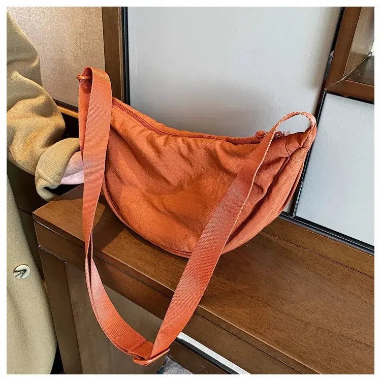 Casual nylon hobo crossbody bag in orange with a wide adjustable strap