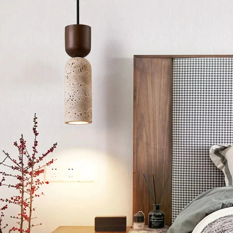 Bedside chandelier with a beige speckled cylindrical shade and dark brown cap in a Japanese wabi-sabi style bedroom.