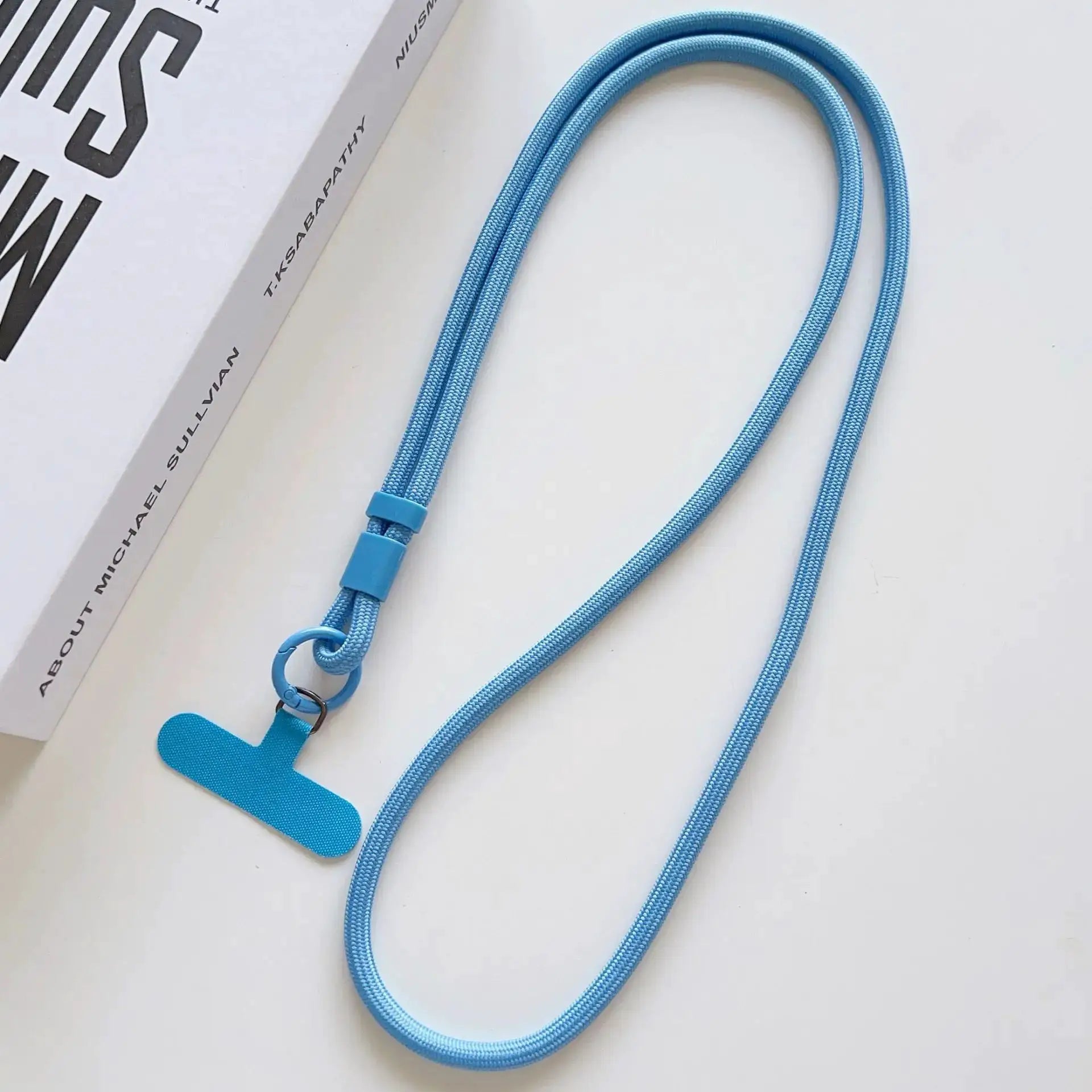 Blue braided phone lanyard with metal ring and clip; adjustable plastic slider; Simples Market branding.