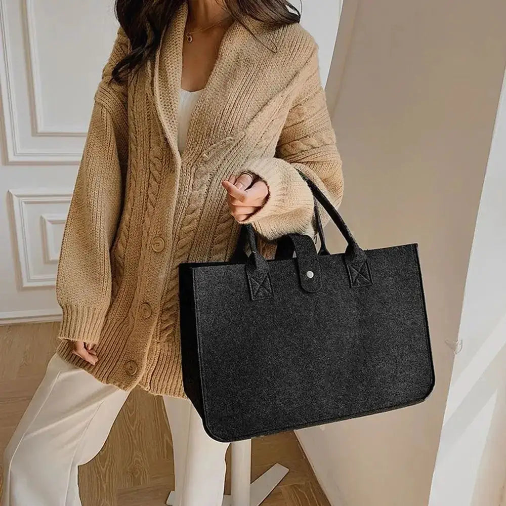 Large black felt tote bag with dual handles and front strap snap, casual travel handbag