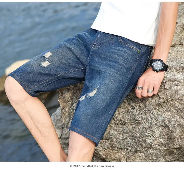Men's blue denim shorts with distressed patches, knee-length casual wear
