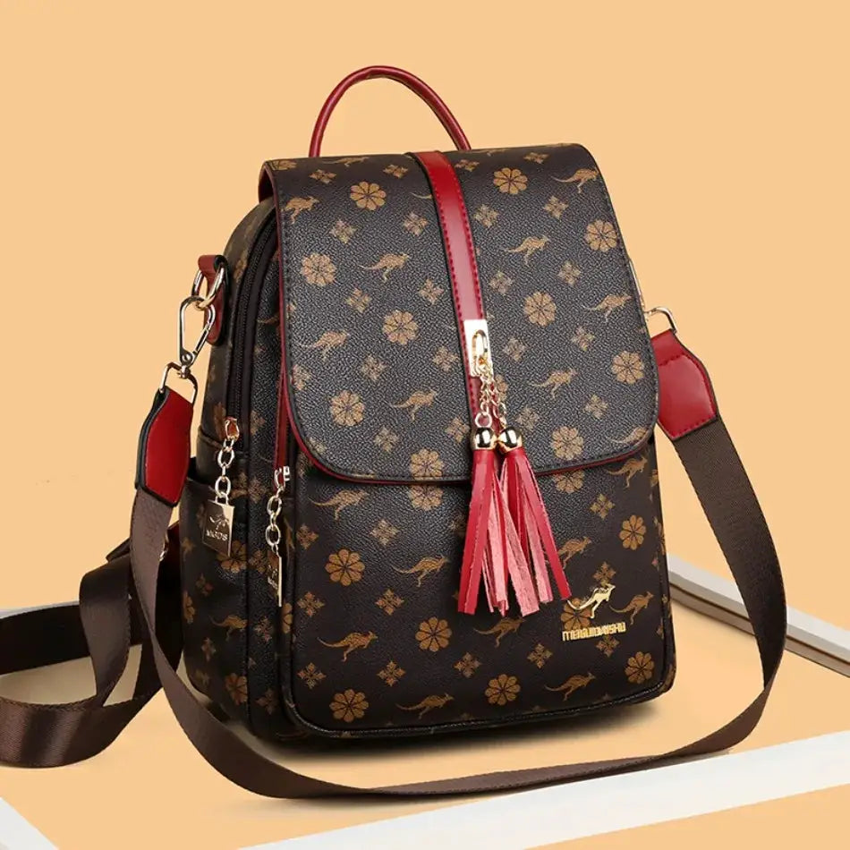 Ladies designer leather backpack with gold floral print, red tassels, brown strap, large capacity.